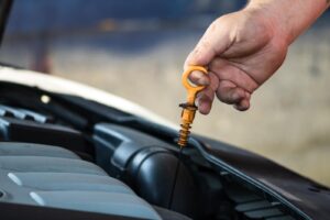 A photo of a car mechanic checking the engine oil level