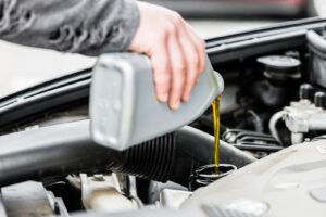 A mechanic filling the engine oil in a customer's car