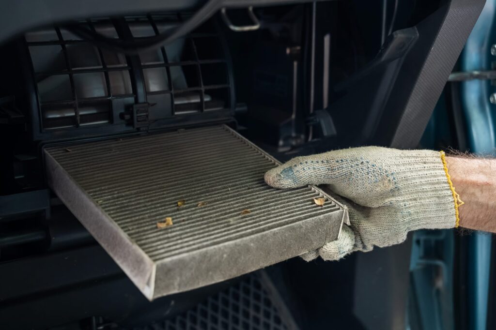 A mechanic changing the cabin air filter in a vehicle