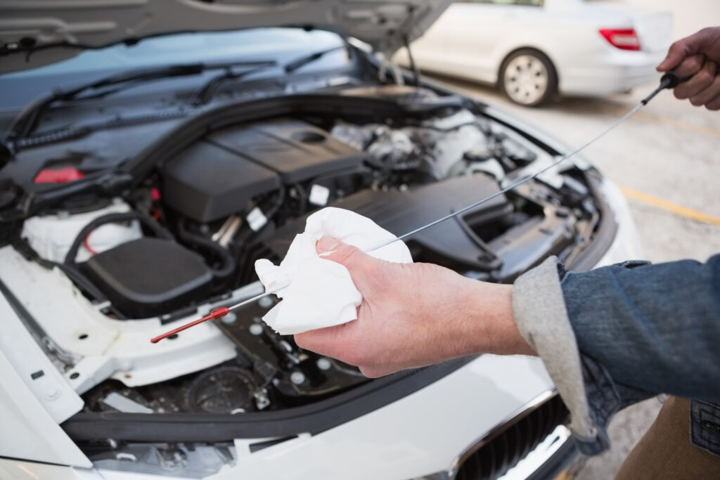 Close-up of a man checking the oil in a car engine