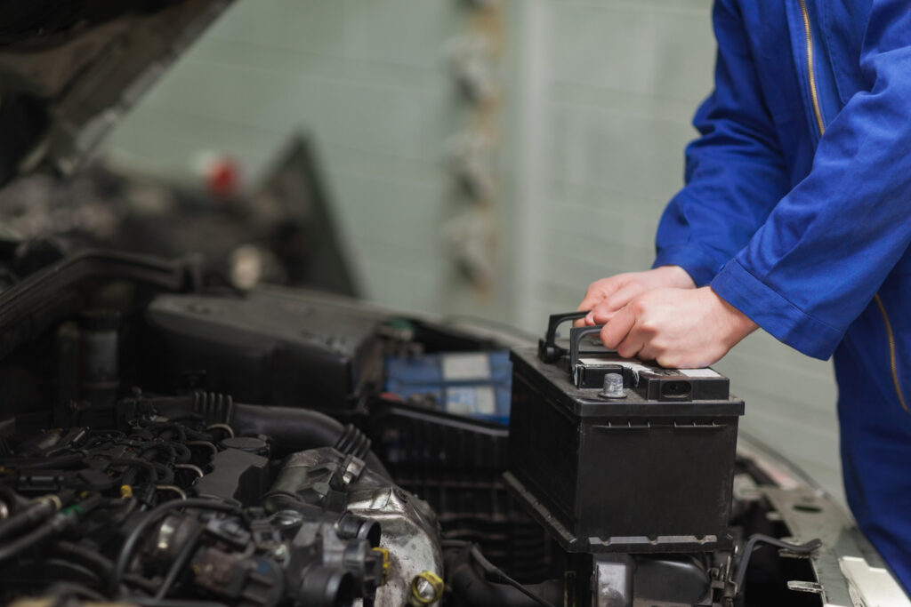 A technician removing a battery from a vehicle