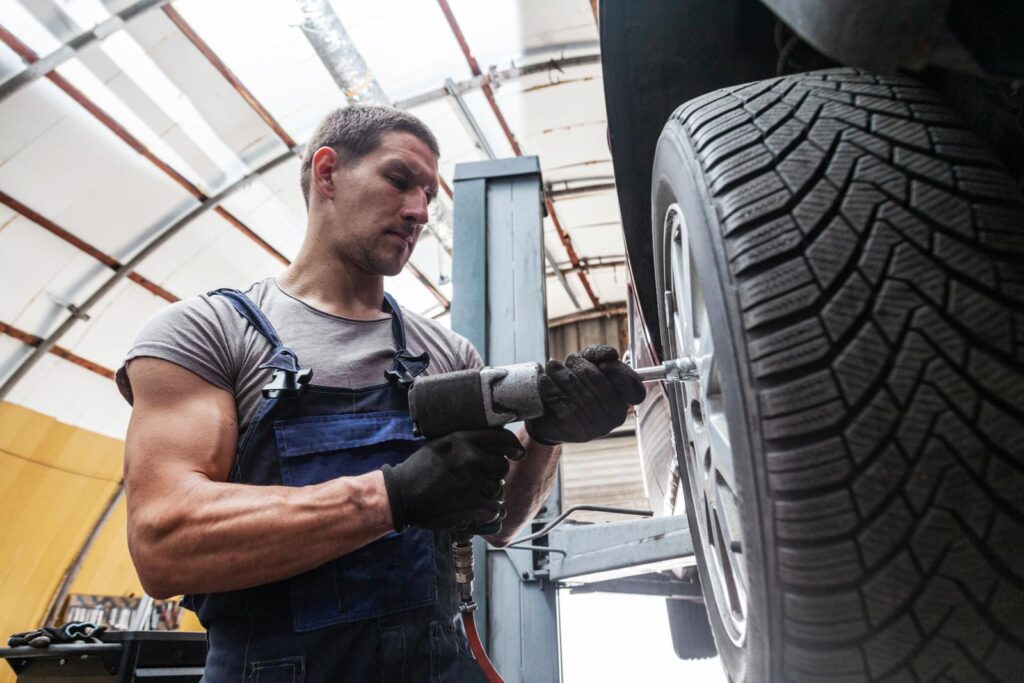A mechanic removing a tire on a vehicle