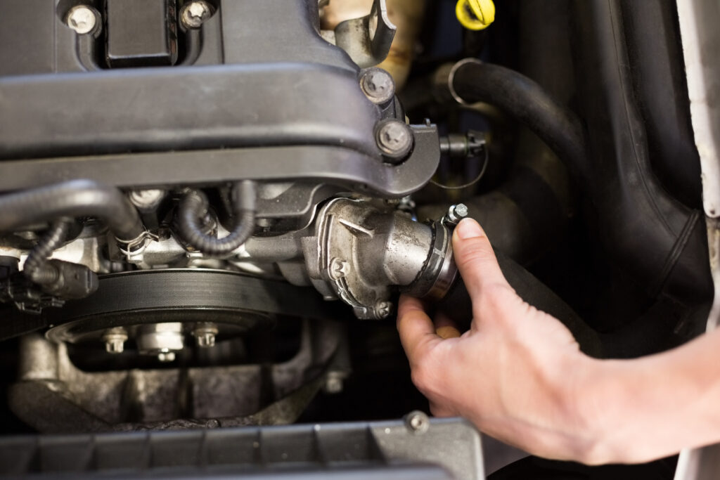 a Mechanic Checking the Radiator Hose on an Engine A mechanic checking the radiator hose on an engine