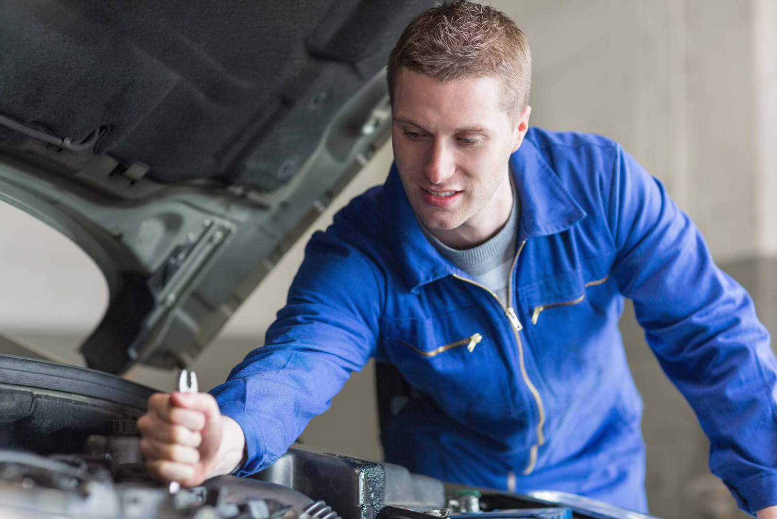 A mechanic working on the engine of an automobile