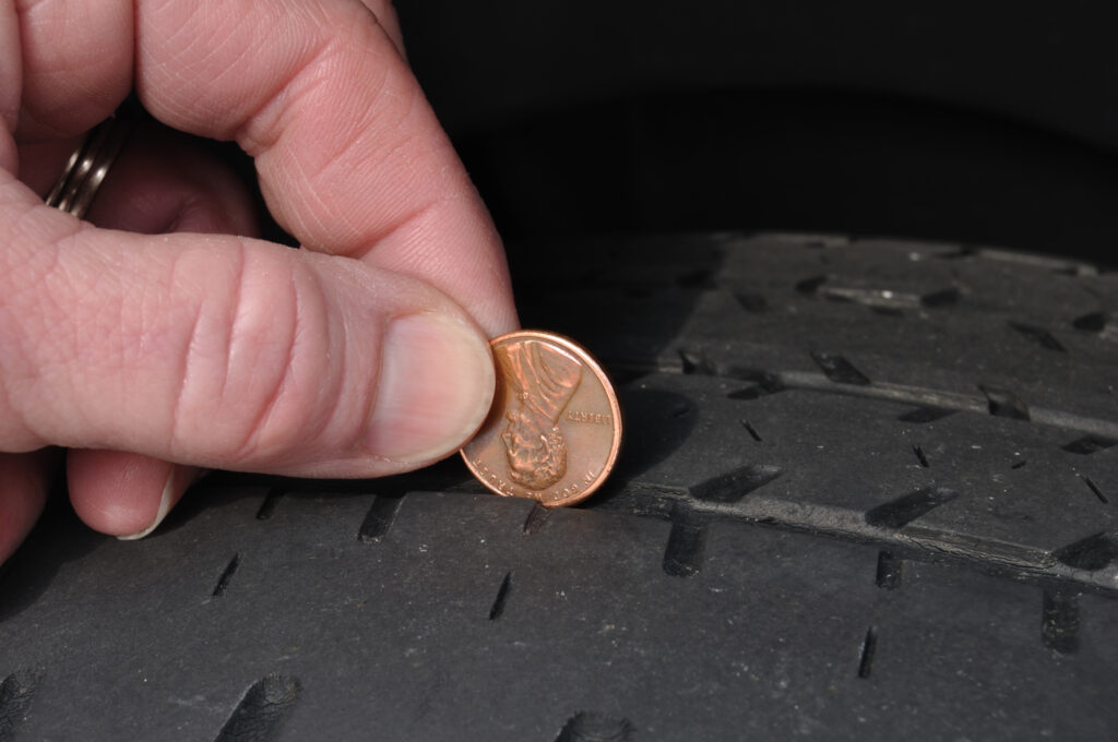 Using a penny to check the depth of remaining tread on a tire
