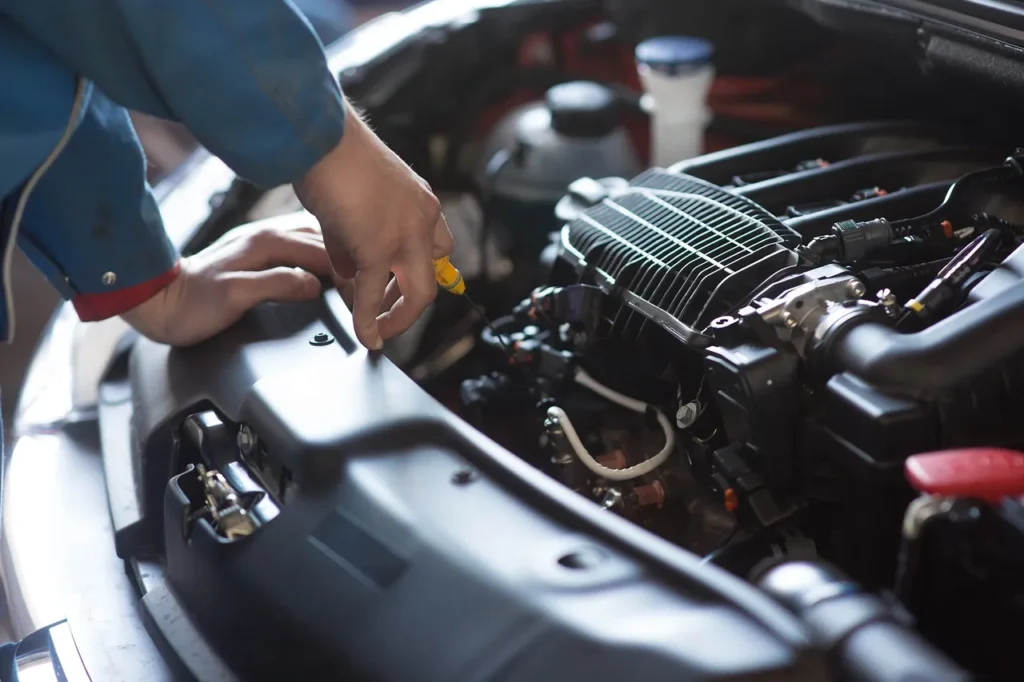 a Photo of a Mechanic Checking Engine Oil Level on a Customer's Vehicle A photo of a mechanic checking engine oil level on a customer's vehicle