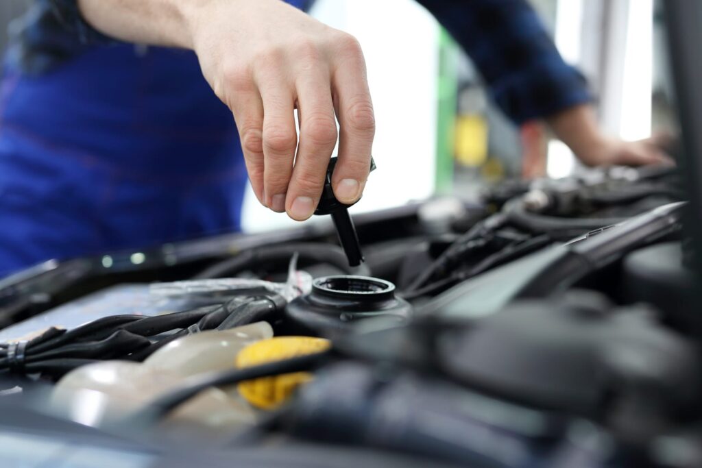 A mechanic checking the power steering fluid in a vehicle