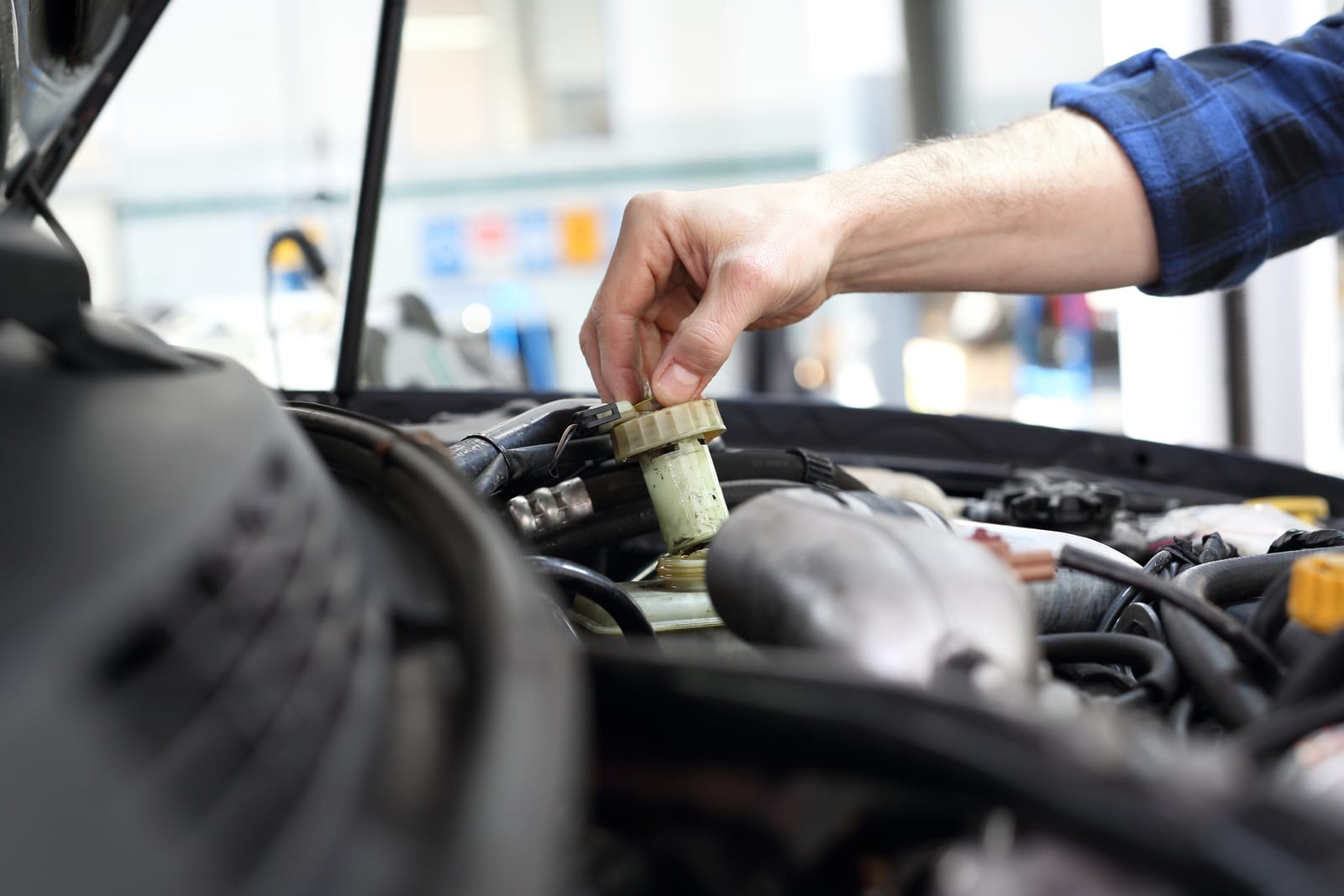 A mechanic checking the power steering fluid in a vehicle