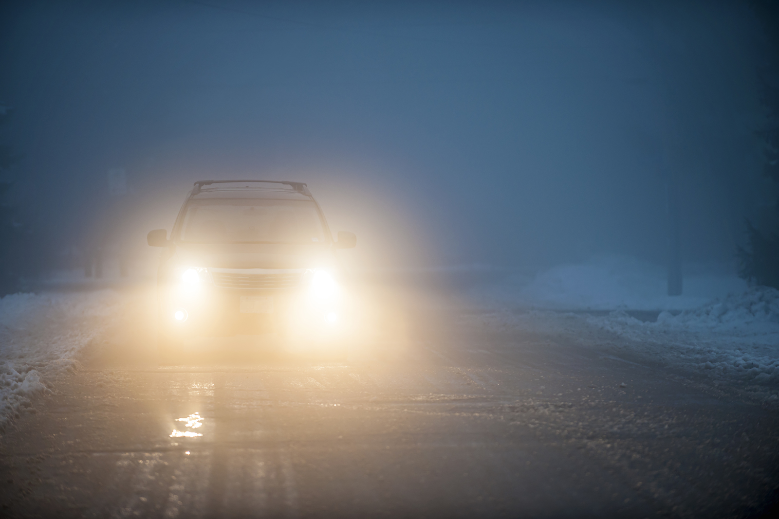 Car driving in the dark on a snowy road
