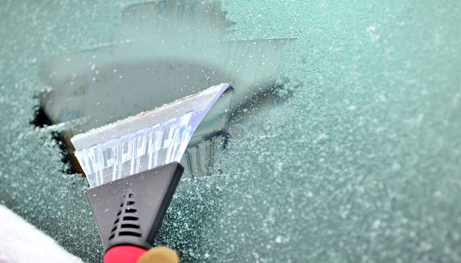 Using an ice scrapper on a frozen windshield