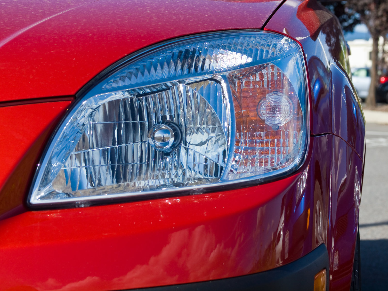 Headlights of a red sedan
