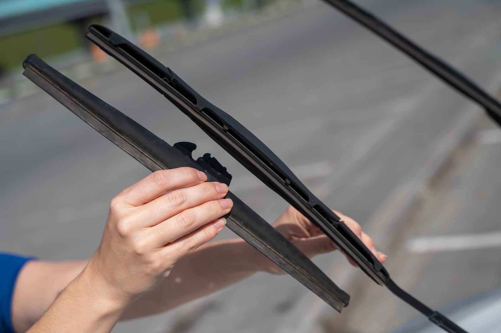 A close-up of a maintenance technician changing windshield wiper blades