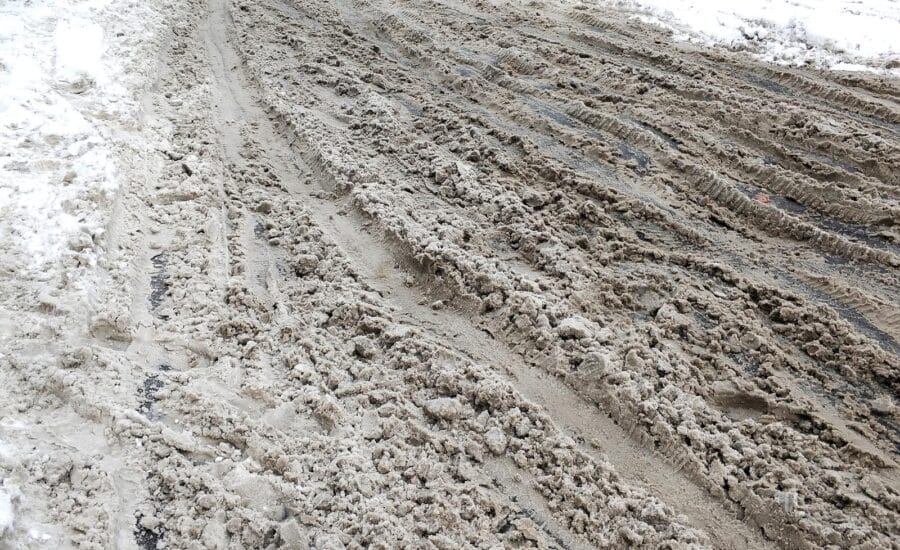 Snow and dirt on the road. Uncleared city roads in winter