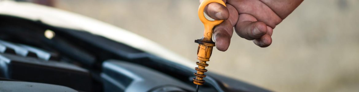 A photo of a car mechanic checking the engine oil level